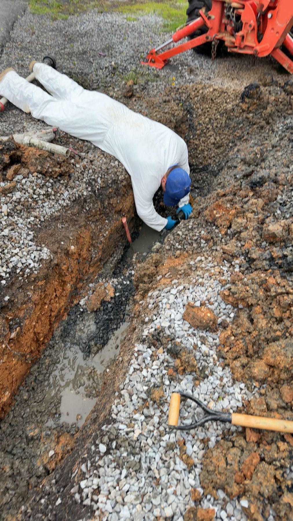 Excavated septic line opened for drain cleaning and blockage repair.