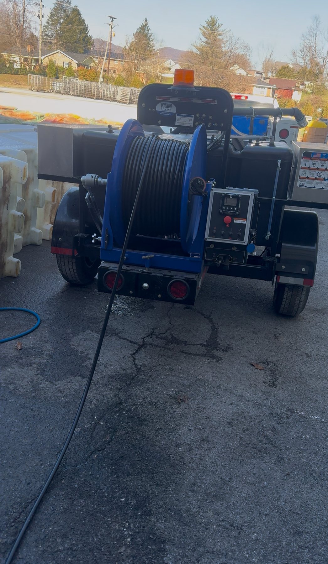 Trailer-mounted sewer jetter and hose reel used for sewer jetting and line cleaning.