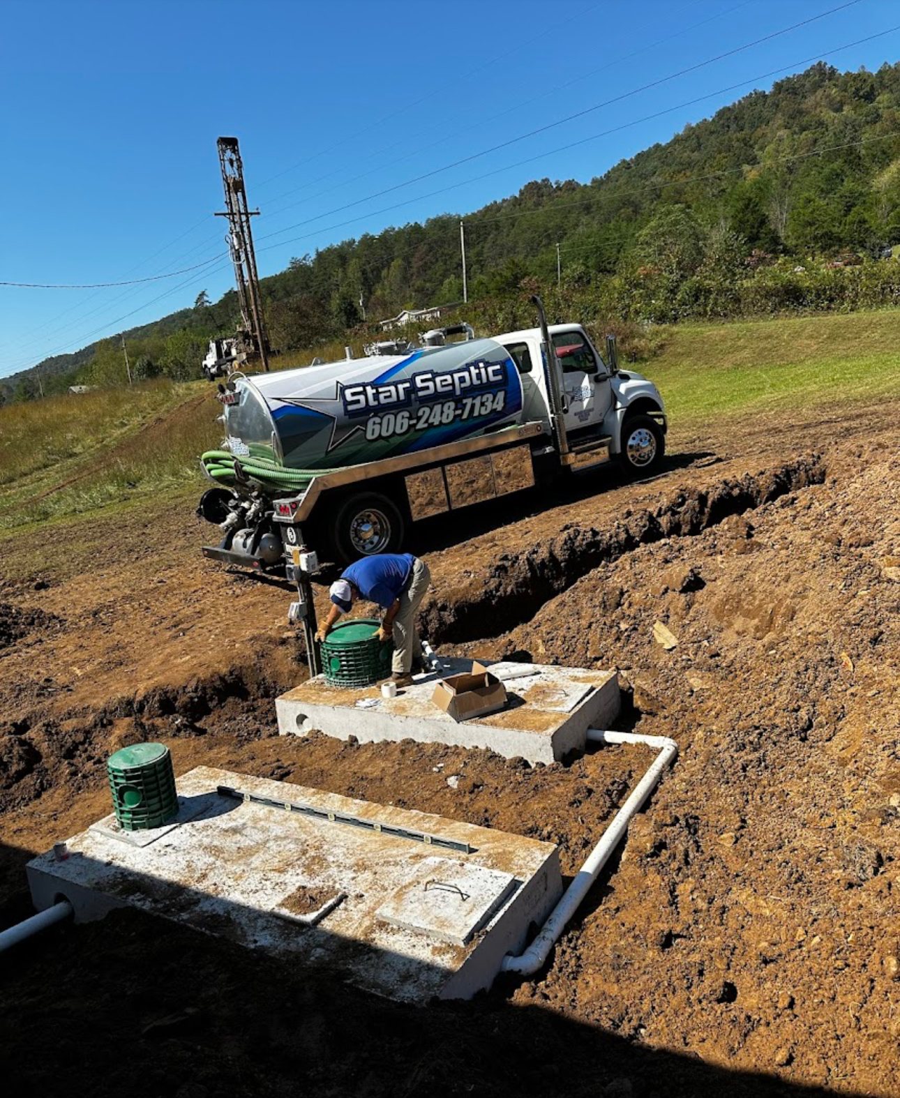 Small Star Septic pump truck servicing a lake-area septic system.